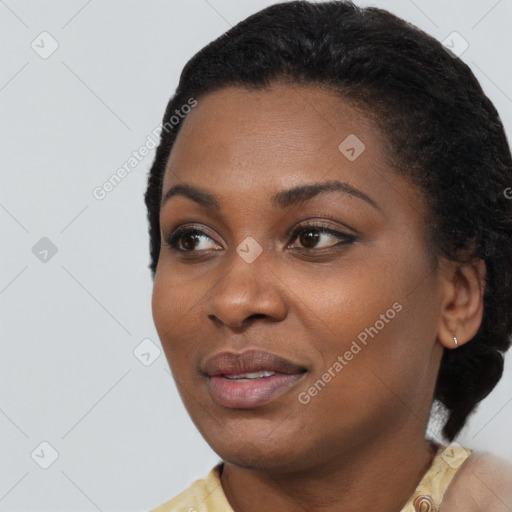 Joyful black young-adult female with short  black hair and brown eyes