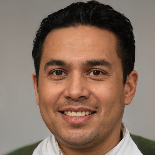 Joyful white adult male with short  black hair and brown eyes