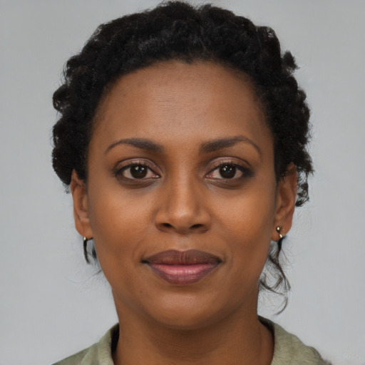 Joyful black young-adult female with short  black hair and brown eyes