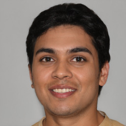 Joyful latino young-adult male with short  black hair and brown eyes