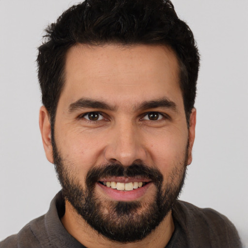 Joyful white young-adult male with short  black hair and brown eyes