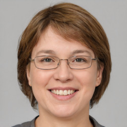 Joyful white adult female with medium  brown hair and grey eyes