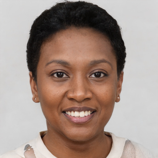Joyful black young-adult female with short  black hair and brown eyes