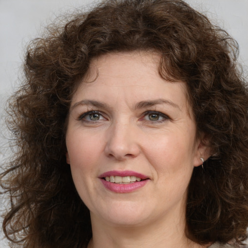 Joyful white adult female with long  brown hair and green eyes