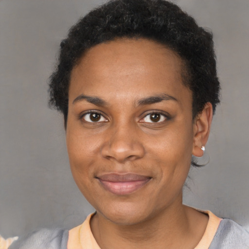 Joyful black young-adult female with short  black hair and brown eyes