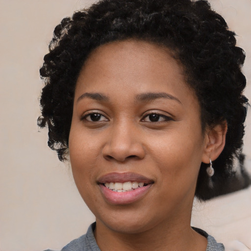 Joyful black young-adult female with medium  black hair and brown eyes