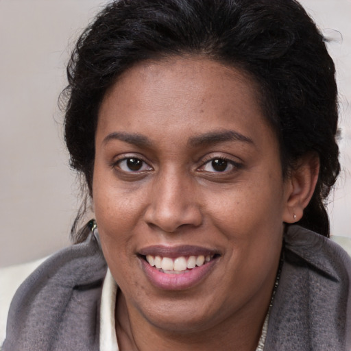 Joyful latino adult female with medium  brown hair and brown eyes