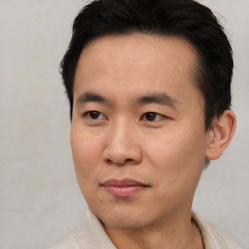 Joyful asian young-adult male with short  brown hair and brown eyes
