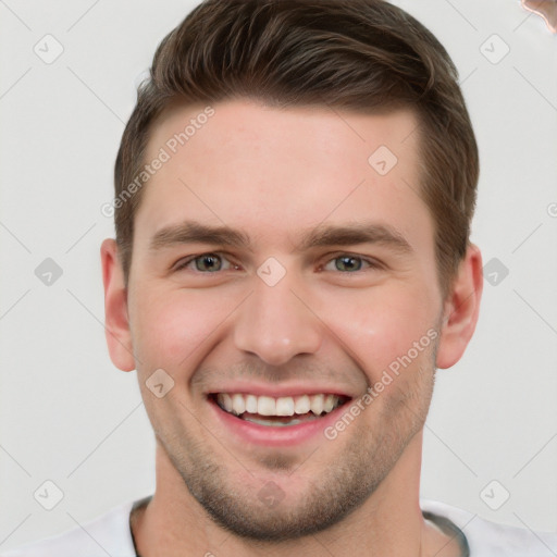 Joyful white young-adult male with short  brown hair and grey eyes