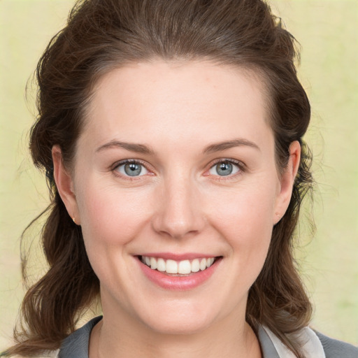 Joyful white young-adult female with medium  brown hair and grey eyes