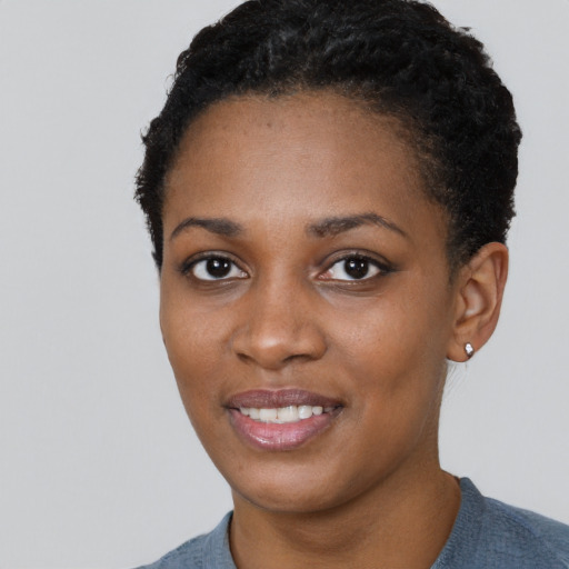 Joyful black young-adult female with short  black hair and brown eyes