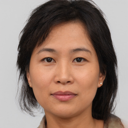 Joyful asian adult female with medium  brown hair and brown eyes