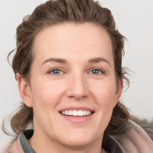 Joyful white young-adult female with medium  brown hair and grey eyes