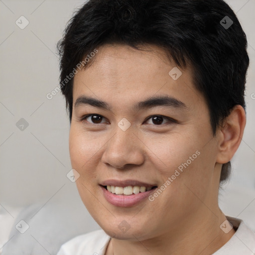 Joyful asian young-adult male with short  brown hair and brown eyes