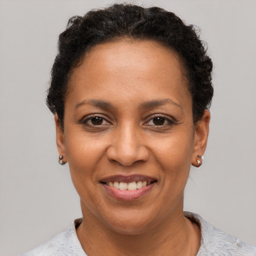 Joyful black adult female with short  black hair and brown eyes