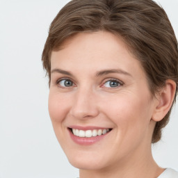 Joyful white young-adult female with medium  brown hair and green eyes