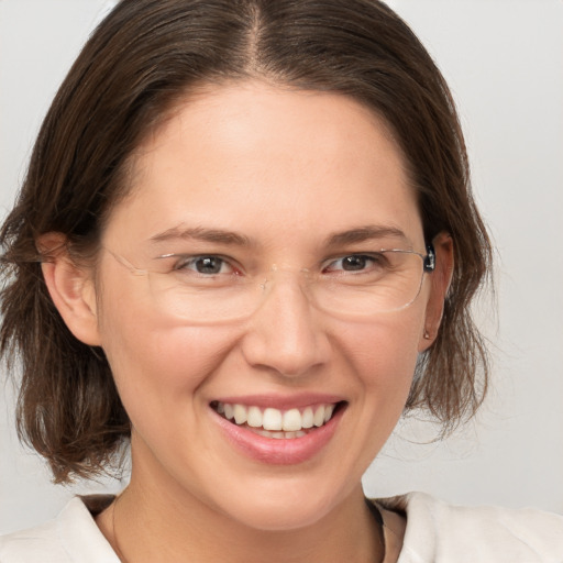 Joyful white adult female with medium  brown hair and grey eyes