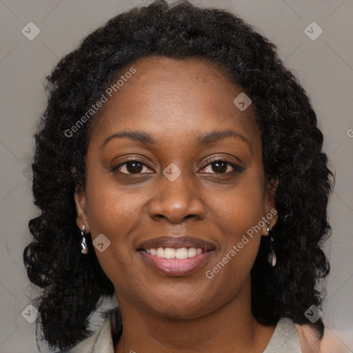 Joyful black young-adult female with long  brown hair and brown eyes