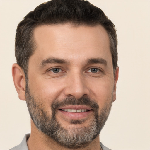 Joyful white adult male with short  brown hair and brown eyes