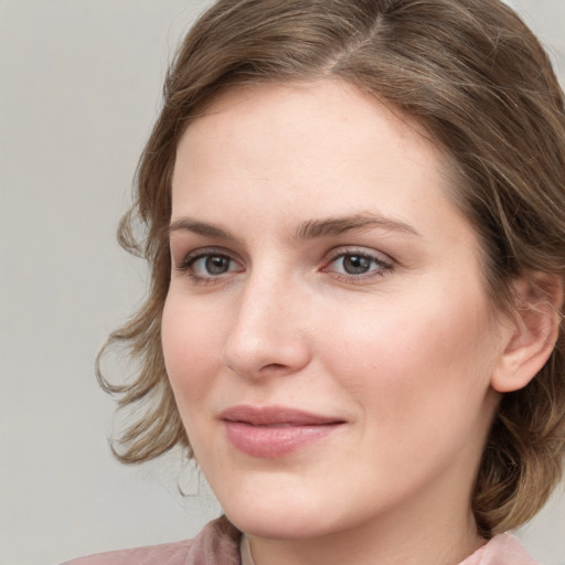 Joyful white young-adult female with medium  brown hair and blue eyes