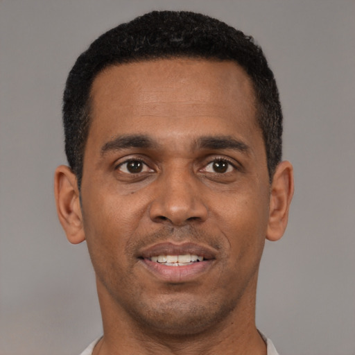 Joyful black young-adult male with short  black hair and brown eyes