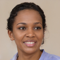 Joyful black young-adult female with long  brown hair and brown eyes