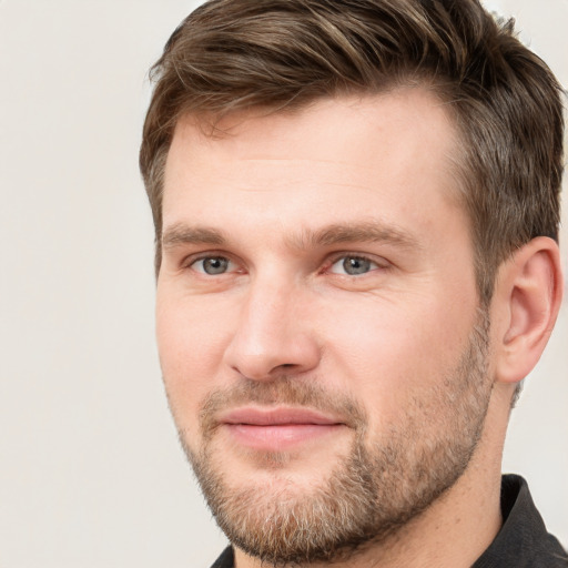 Joyful white young-adult male with short  brown hair and grey eyes