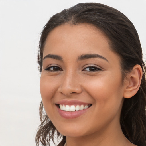 Joyful latino young-adult female with long  brown hair and brown eyes