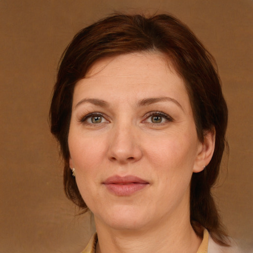 Joyful white adult female with medium  brown hair and green eyes