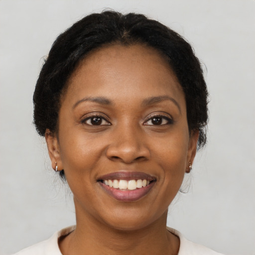 Joyful black young-adult female with medium  brown hair and brown eyes
