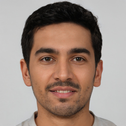 Joyful latino young-adult male with short  black hair and brown eyes