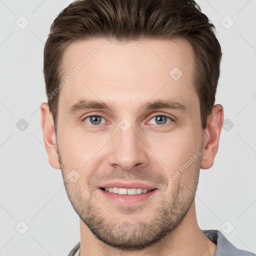 Joyful white young-adult male with short  brown hair and grey eyes