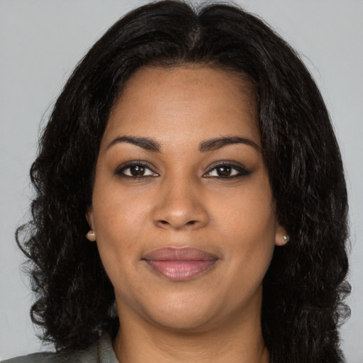 Joyful black young-adult female with long  black hair and brown eyes