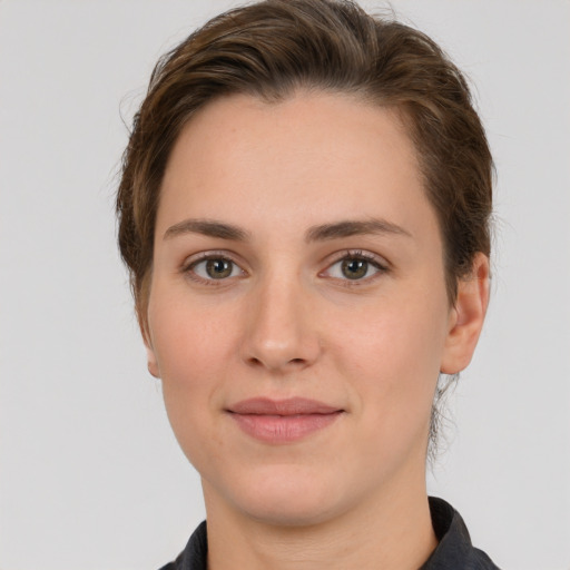 Joyful white young-adult female with short  brown hair and grey eyes