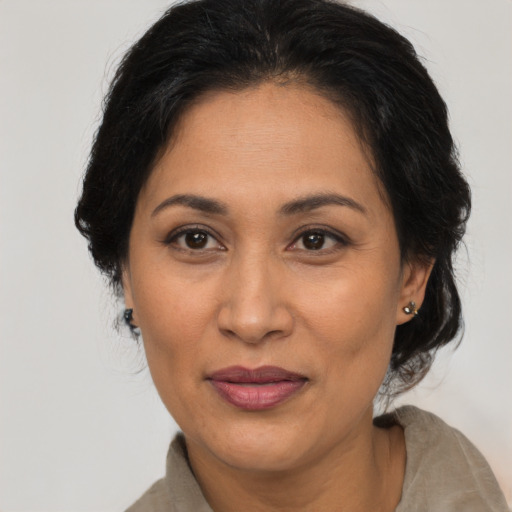 Joyful latino adult female with medium  brown hair and brown eyes