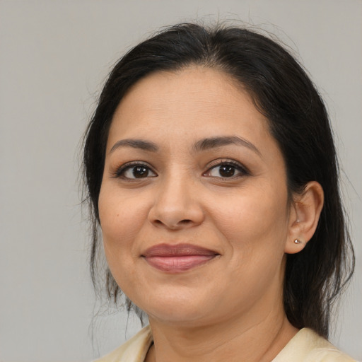 Joyful latino adult female with medium  brown hair and brown eyes