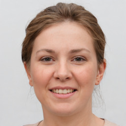 Joyful white young-adult female with medium  brown hair and grey eyes