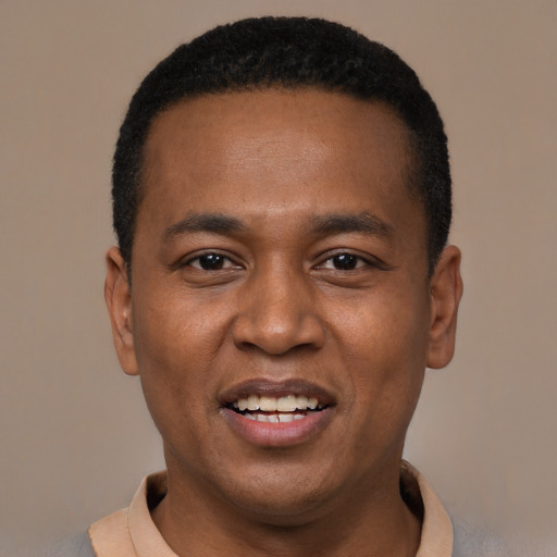 Joyful black young-adult male with short  black hair and brown eyes