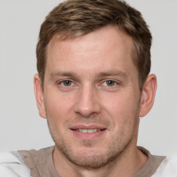 Joyful white young-adult male with short  brown hair and grey eyes