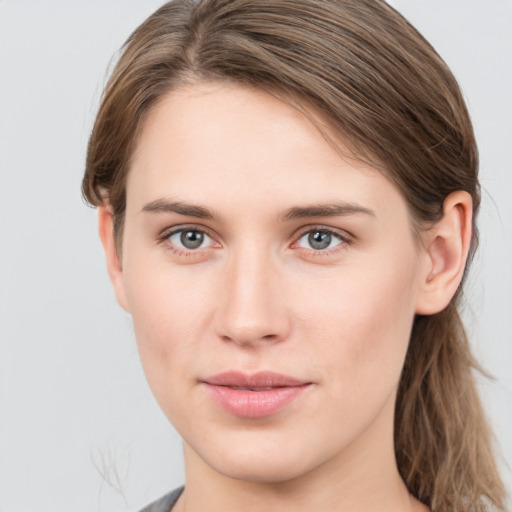 Joyful white young-adult female with medium  brown hair and grey eyes