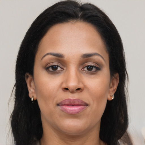 Joyful latino adult female with long  brown hair and brown eyes