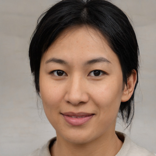 Joyful asian young-adult female with medium  brown hair and brown eyes