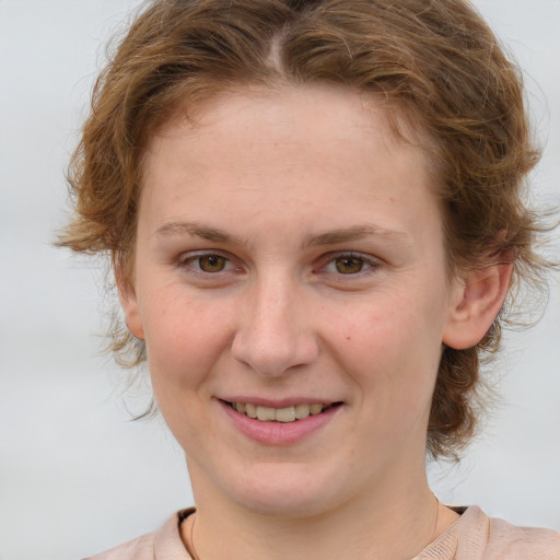 Joyful white young-adult female with medium  brown hair and blue eyes