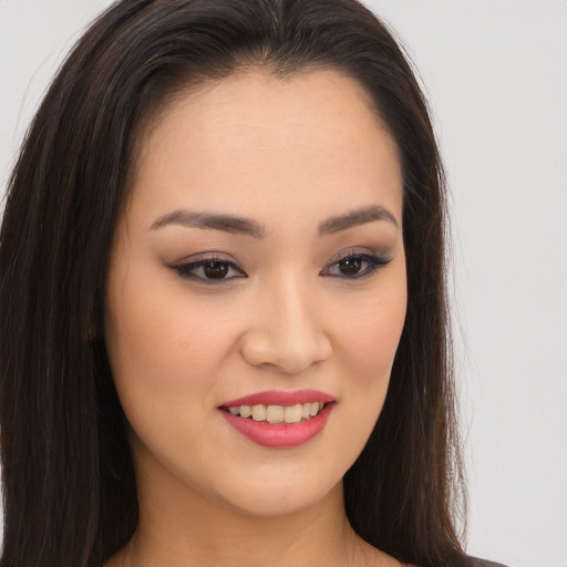 Joyful asian young-adult female with long  brown hair and brown eyes