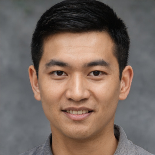 Joyful asian young-adult male with short  black hair and brown eyes