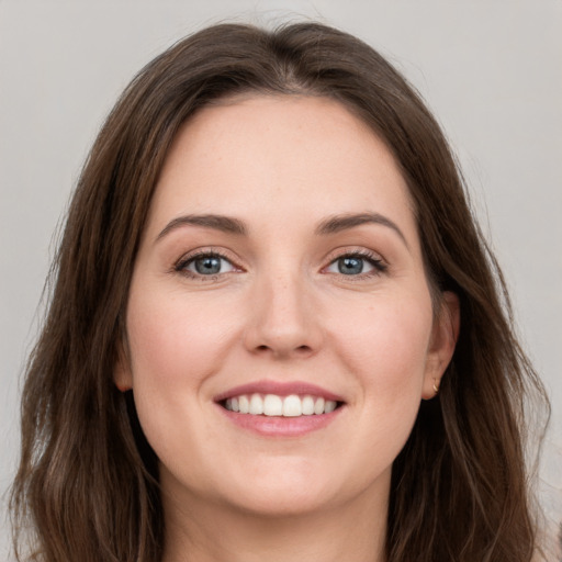 Joyful white young-adult female with long  brown hair and grey eyes