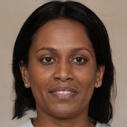 Joyful black adult female with medium  black hair and brown eyes