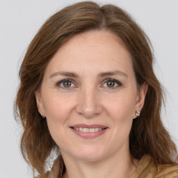 Joyful white adult female with long  brown hair and grey eyes