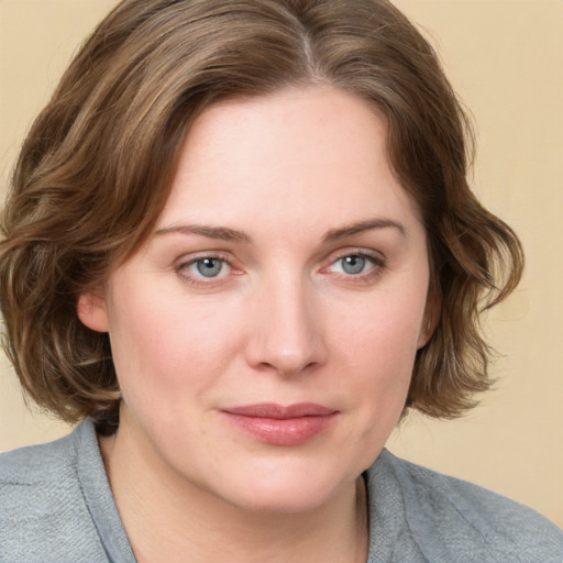 Joyful white young-adult female with medium  brown hair and blue eyes