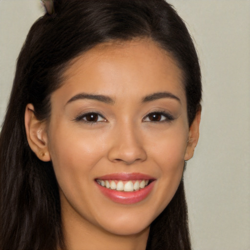 Joyful latino young-adult female with long  brown hair and brown eyes